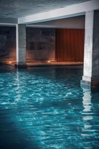 a pool of water in a building with columns at Radisson Resort Kołobrzeg in Kołobrzeg
