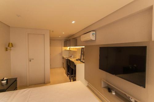 a room with a large flat screen tv on a wall at Manaíra Apart Hotel por Carpediem in Tambaú