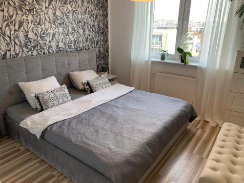 a bedroom with a bed with pillows on it at Apartament Wanessa in Gdańsk