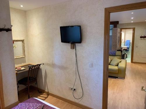 a living room with a television on the wall at El Rinconcillo - centro histórico de Toledo in Toledo