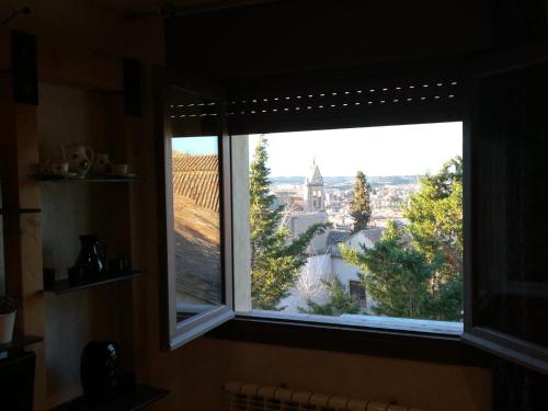 a window with a view of a city at El Rinconcillo - centro histórico de Toledo in Toledo