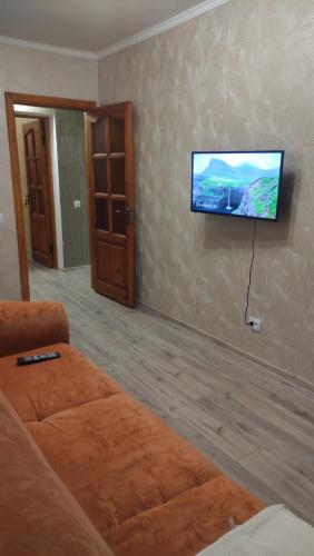 a living room with a couch and a flat screen tv at Apartments near the Trinity Church on Dovzhenko Street,102 in Chernihiv