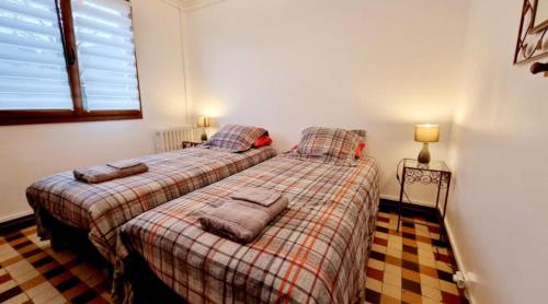 two beds in a bedroom with two lamps on them at Le Dom’Aisne à Zabeth, lieu simple et paisible *** in Chevregny