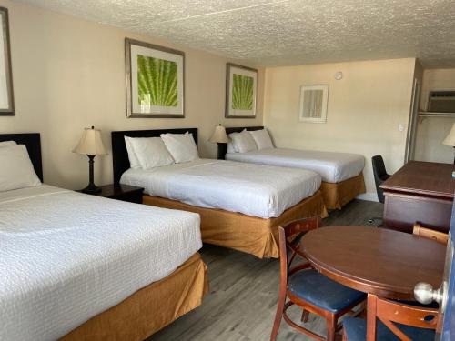 Habitación de hotel con 2 camas y mesa en Ocean 5 Hotel en Myrtle Beach