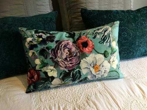 a pillow with flowers on it on a bed at Karapiro Willows Luxury B & B in Cambridge