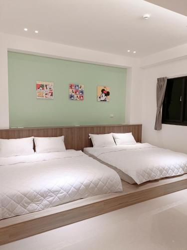 two beds sitting next to each other in a bedroom at Penghu Michi Homestay in Hsing-wen
