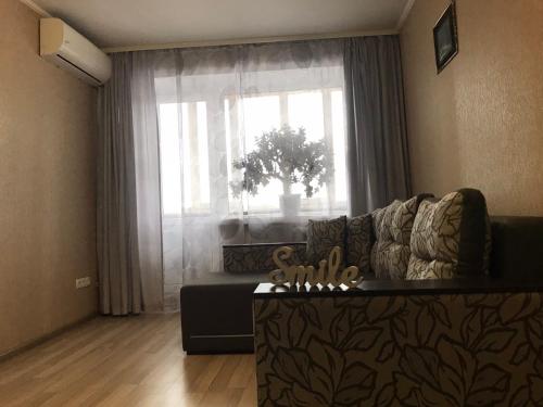 sala de estar con sofá y ventana en Apartment with balcony on Peremohy Avenue 43, en Cherníhiv