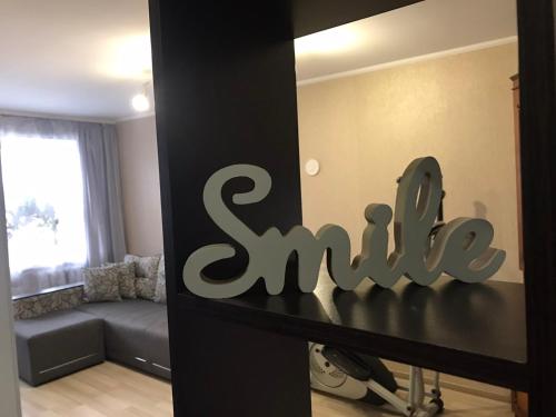 a living room with a couch and a sign that saysasy at Apartment with balcony on Peremohy Avenue 43 in Chernihiv