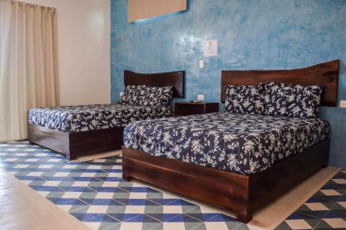 una camera con due letti e una parete blu di Apartamentos Del Mar El Cuyo a El Cuyo