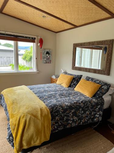 1 dormitorio con 1 cama y 2 ventanas en Sundari Retreat en Otaki