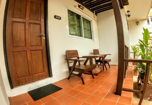 Habitación con puerta de madera, mesa y sillas en ไทยโฮเต็ล, en Buriram