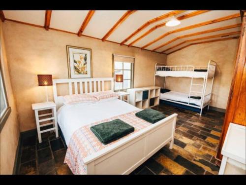 a bedroom with a bed and two bunk beds at Pooh Corner, Cottage in Robe