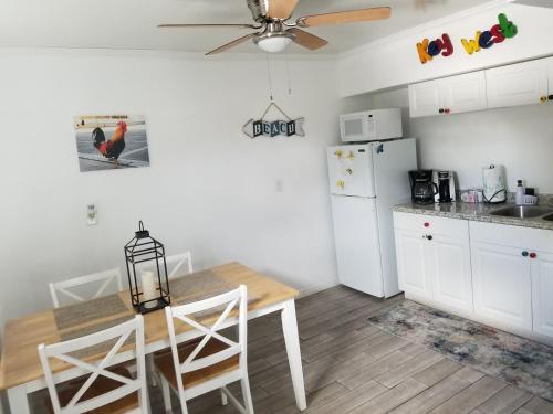a kitchen with a table and a white refrigerator at Old Town Suites in Key West