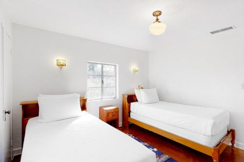 two beds in a room with white walls and a window at Lazy C Ranch in Tucson