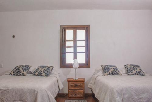 a room with two beds and a window at Hotel Posada las Nubes in Parras de la Fuente