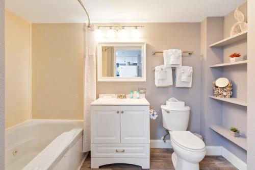 a bathroom with a white toilet and a sink and a tub at Bay Watch 0439 in Myrtle Beach