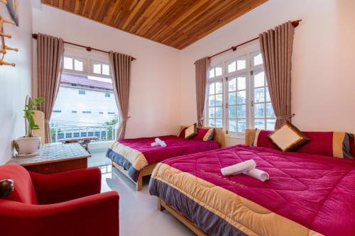 a bedroom with two beds and a chair at Villa Trung nghĩa 28 in Da Lat