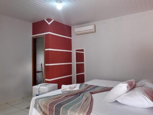 a red and white bedroom with a bed with pillows at Sonho Meu in Nobres