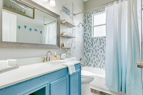 a blue bathroom with a sink and a toilet at Times Like These in Galveston