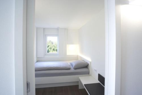niewielka sypialnia z łóżkiem i oknem w obiekcie Ferienwohnungen Stella Regia Stella Regia 1 w mieście Meersburg