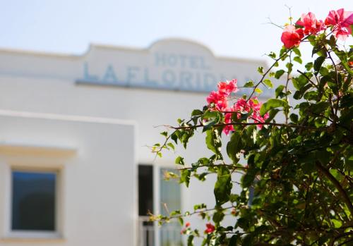 une brousse avec des fleurs roses devant un bâtiment dans l'établissement Hotel La Floridiana, à Capri