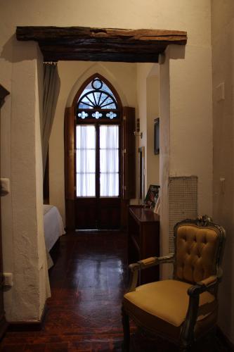 a room with a chair and a door with a window at El Serafin Hotel Boutique in Querétaro