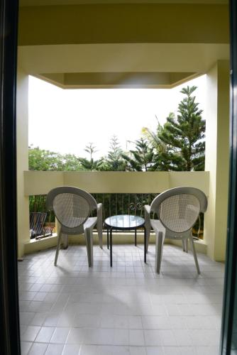 two chairs and a table on a balcony at Days Inn Guam - Tamuning in Tamuning