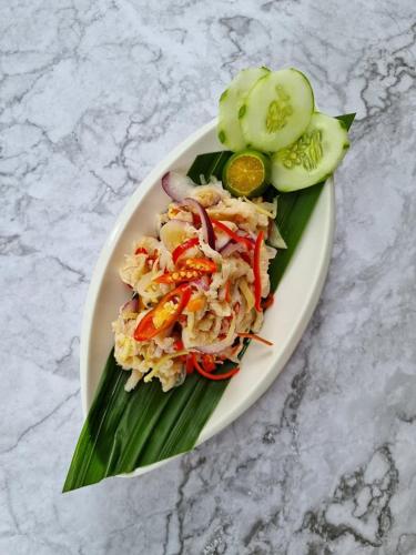 a plate of food with vegetables on a table at Telang Usan Hotel Kuching in Kuching