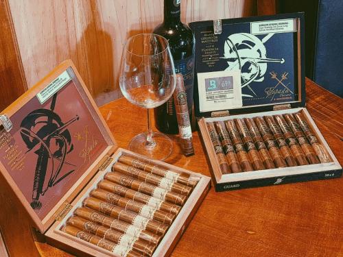 a box of cigars and a glass of wine on a table at Viet Uc Hotel in Ben Tre