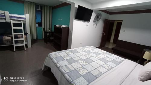 a bedroom with a bed and a tv on the wall at Hotel Santa Maria in Ica