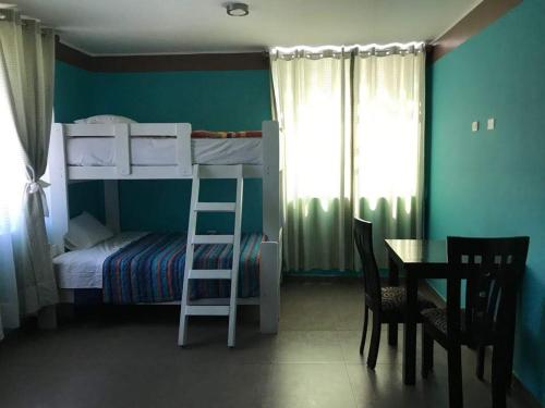 a bedroom with a bunk bed and a table and a ladder at Hotel Santa Maria in Ica