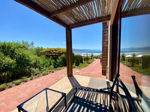 a screened in porch with a bench on a patio at La Vista Lodge in Plettenberg Bay