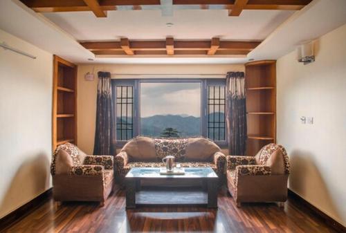 a living room with a couch and chairs and a window at Wintry homes 5 Bhk Villa in Shimla