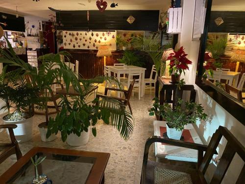 a restaurant with plants and tables and chairs at Hotel La Piazzetta in Mérida