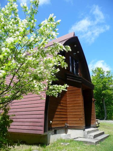 a small house with a pink roof and a tree at Nabekura Kougen Mori-No-Ie in Iiyama