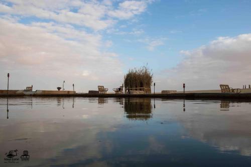 a large body of water with some chairs in it at Hayaat siwa hot spring in Siwa