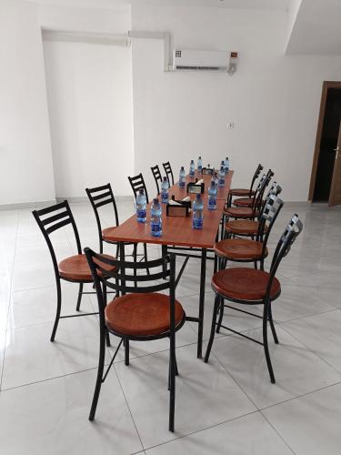 a wooden table with chairs and bottles of water on it at City Centre in Mombasa