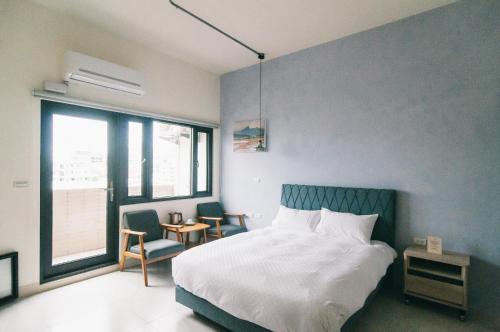 ein Schlafzimmer mit einem weißen Bett und einer blauen Wand in der Unterkunft Coffee&Drinks apt in Hualien