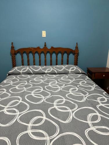a bed with a gray and white bedspread on it at Hotel Paris in San Juan de los Lagos