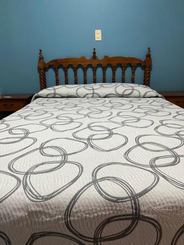 a bed with a blanket with a swirl pattern on it at Hotel Paris in San Juan de los Lagos
