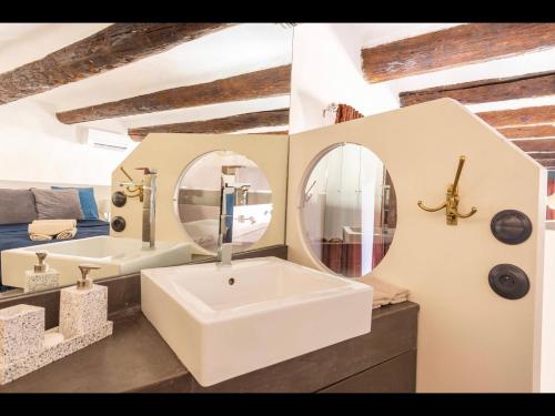 a bathroom with a large white sink and two mirrors at Vieux-Port Magnifique Appartement Loft in Marseille