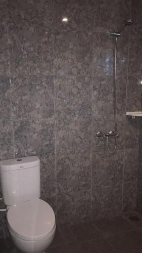 a bathroom with a toilet and a shower at Pondok Mangga in Mataram