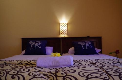 ein Schlafzimmer mit einem großen Bett mit lila Kissen in der Unterkunft Pondok Mangga in Mataram