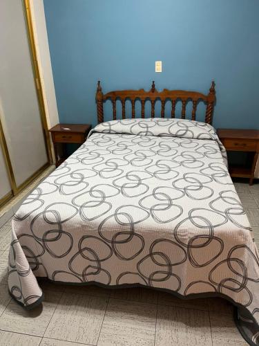 a bed with a brown and white comforter on it at Hotel Paris in San Juan de los Lagos