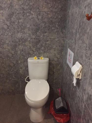 a bathroom with a white toilet in a room at Pondok Mangga in Mataram