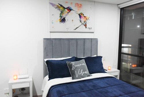 a bedroom with a bed with a painting on the wall at Downtown Bogota Centro Internacional in Bogotá