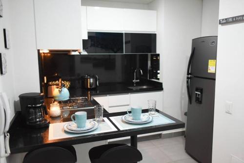 a kitchen with a table with cups and plates on it at Downtown Bogota 15th Floor City View Colpatria Balcony in Bogotá