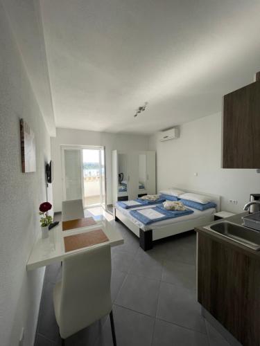 a bedroom with a bed and a kitchen with a sink at Apartments Nevistic in Podstrana