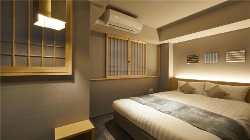 a bedroom with a bed and a air conditioner at KYOTO GION HOTEL in Kyoto