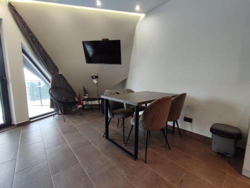 a dining room with a table and chairs and a tv at Diamond Sunrise in Divčibare